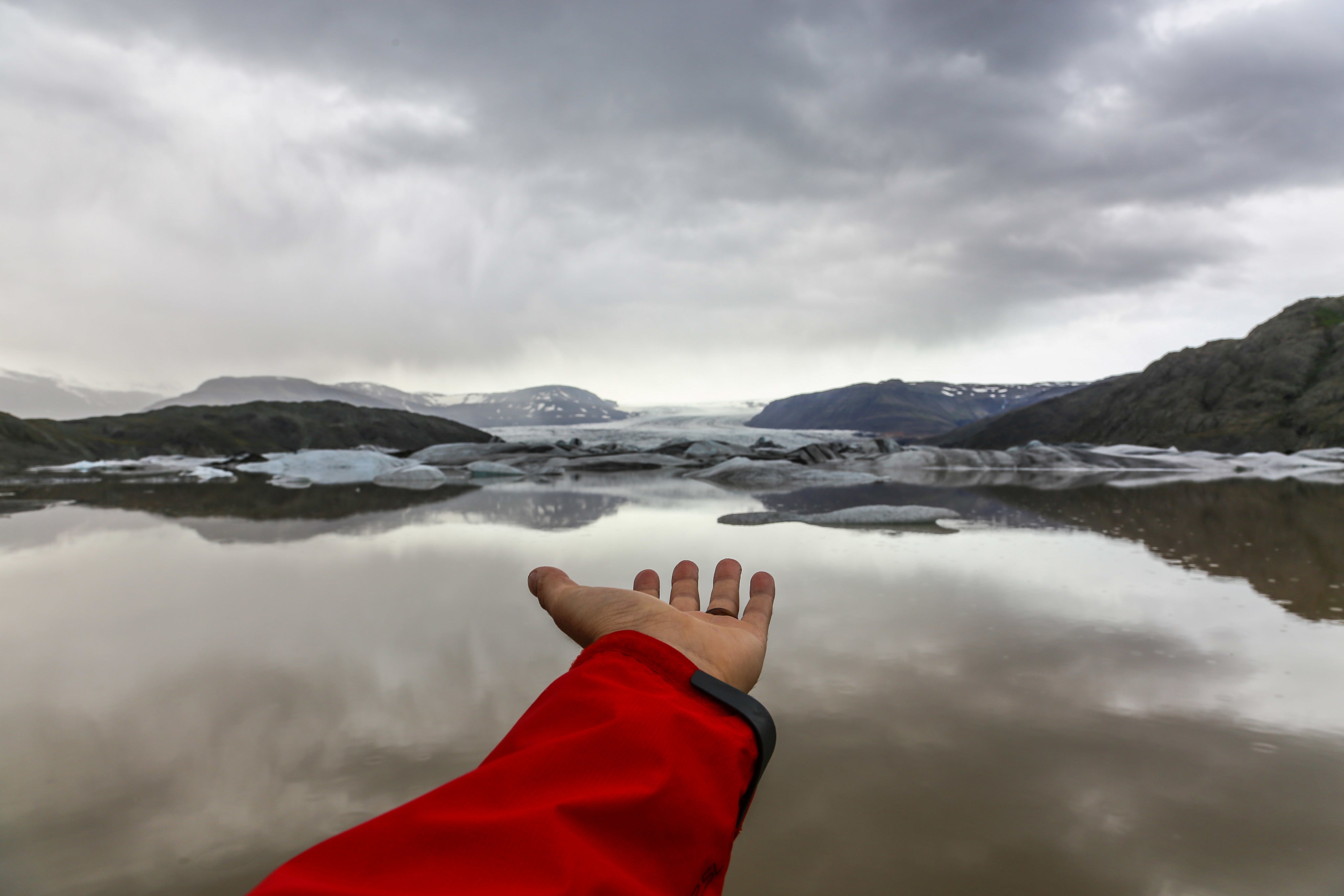 Hand reaching toward icy mountains, symbolizing Longevity Plus vitality and exploration