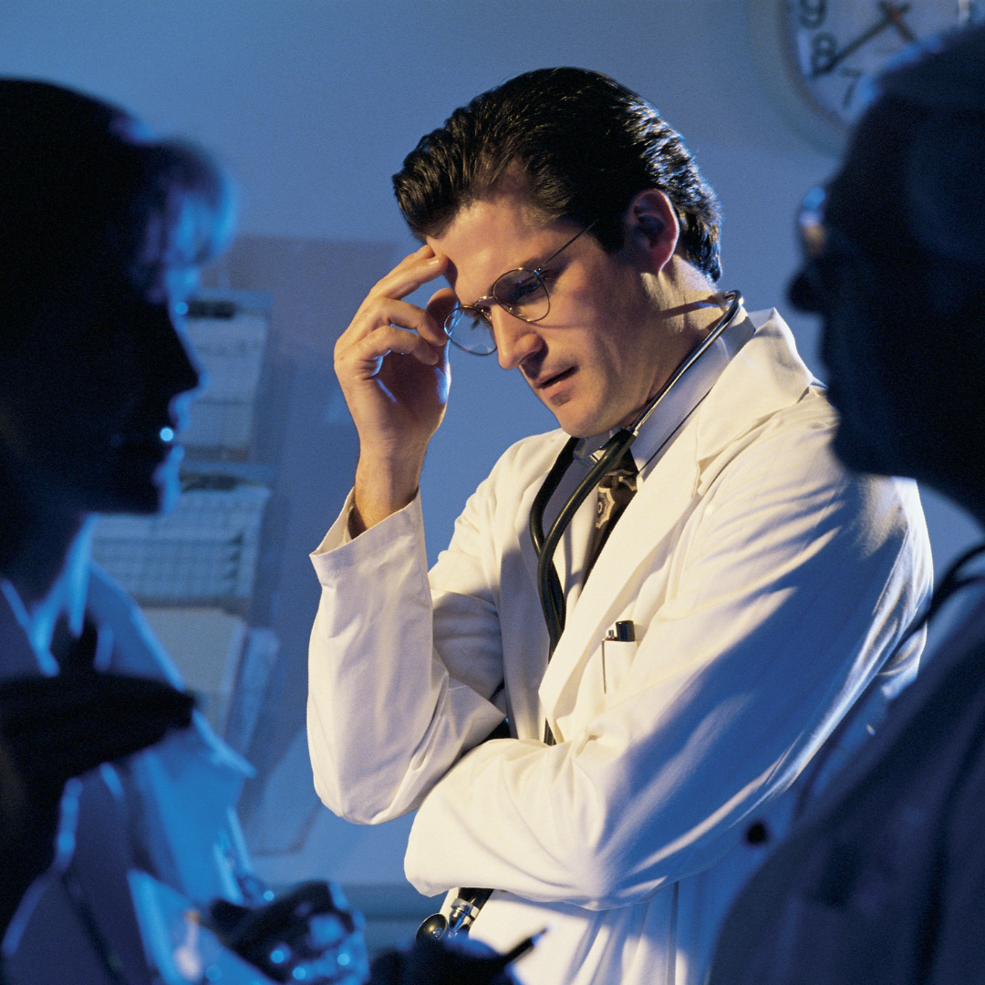 Doctor consulting with colleagues, focused on longevity and preventive healthcare.